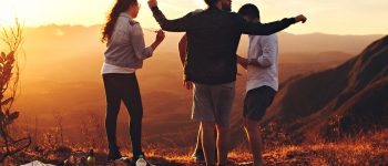 Group of friends at sunset on a hillside