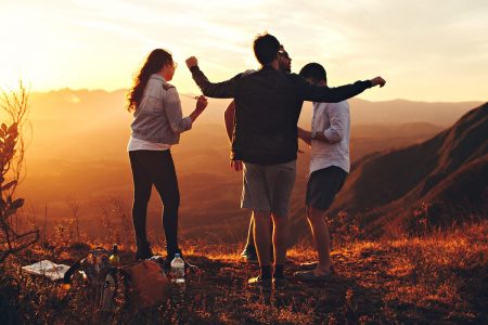 Group of friends at sunset on a hillside