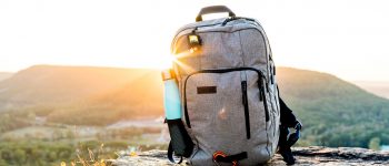 Backpack and water bottle with a sunset behind