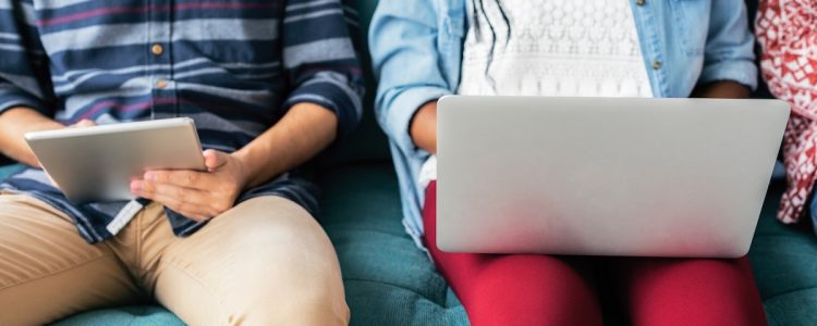 Students with laptops and iPads sitting on a sofa