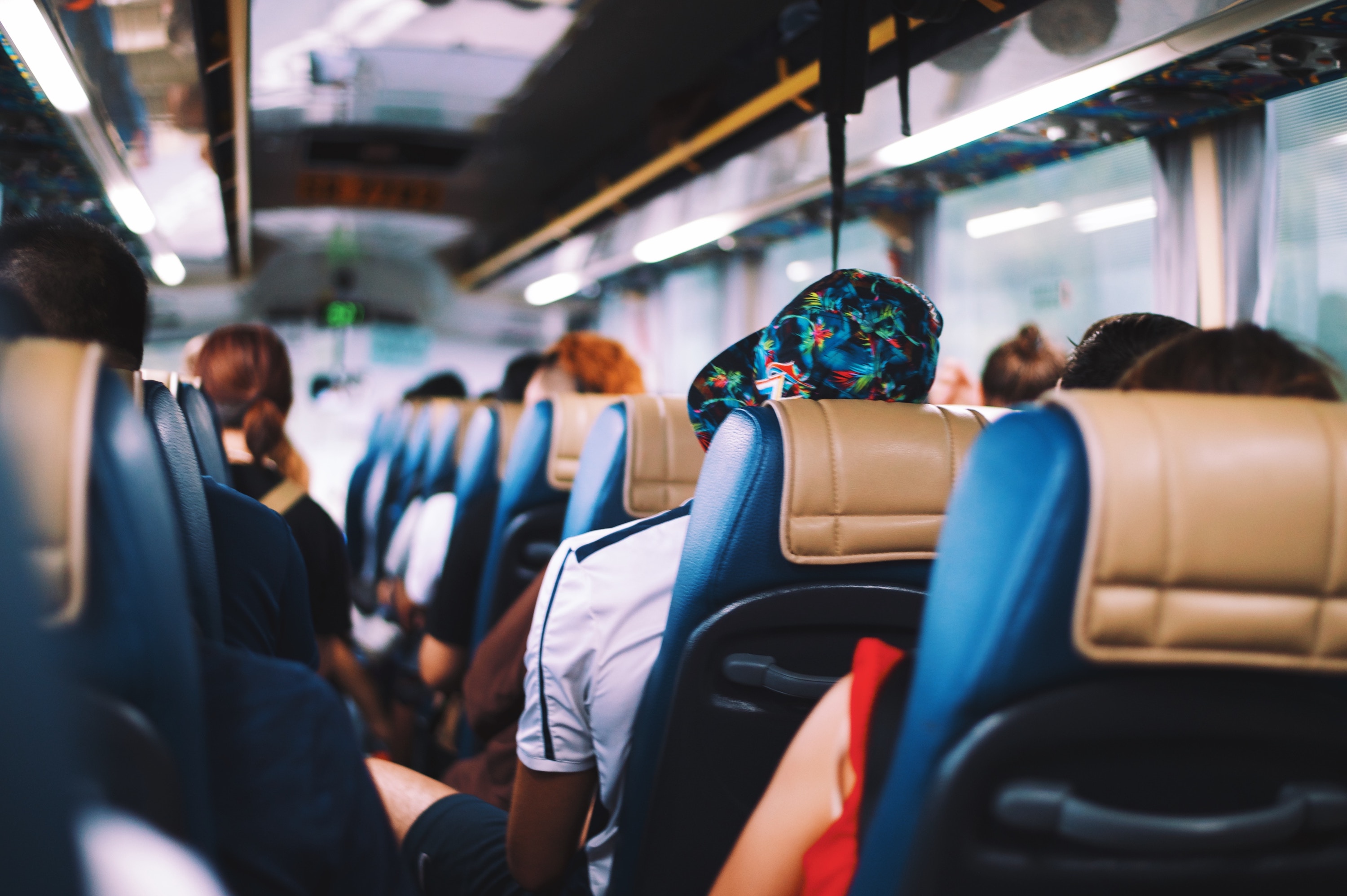  A group of people sitting on a bus are comparing their transportation options.
