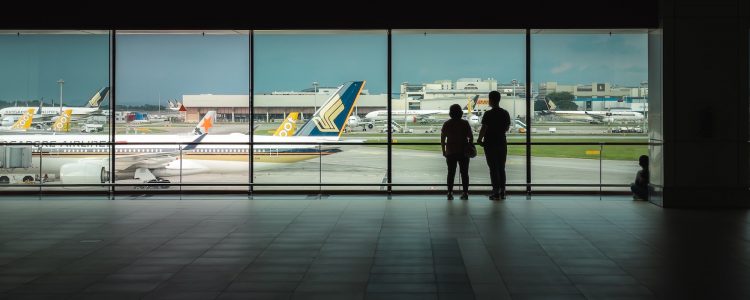 Couple looking at planes through a window at anan airport